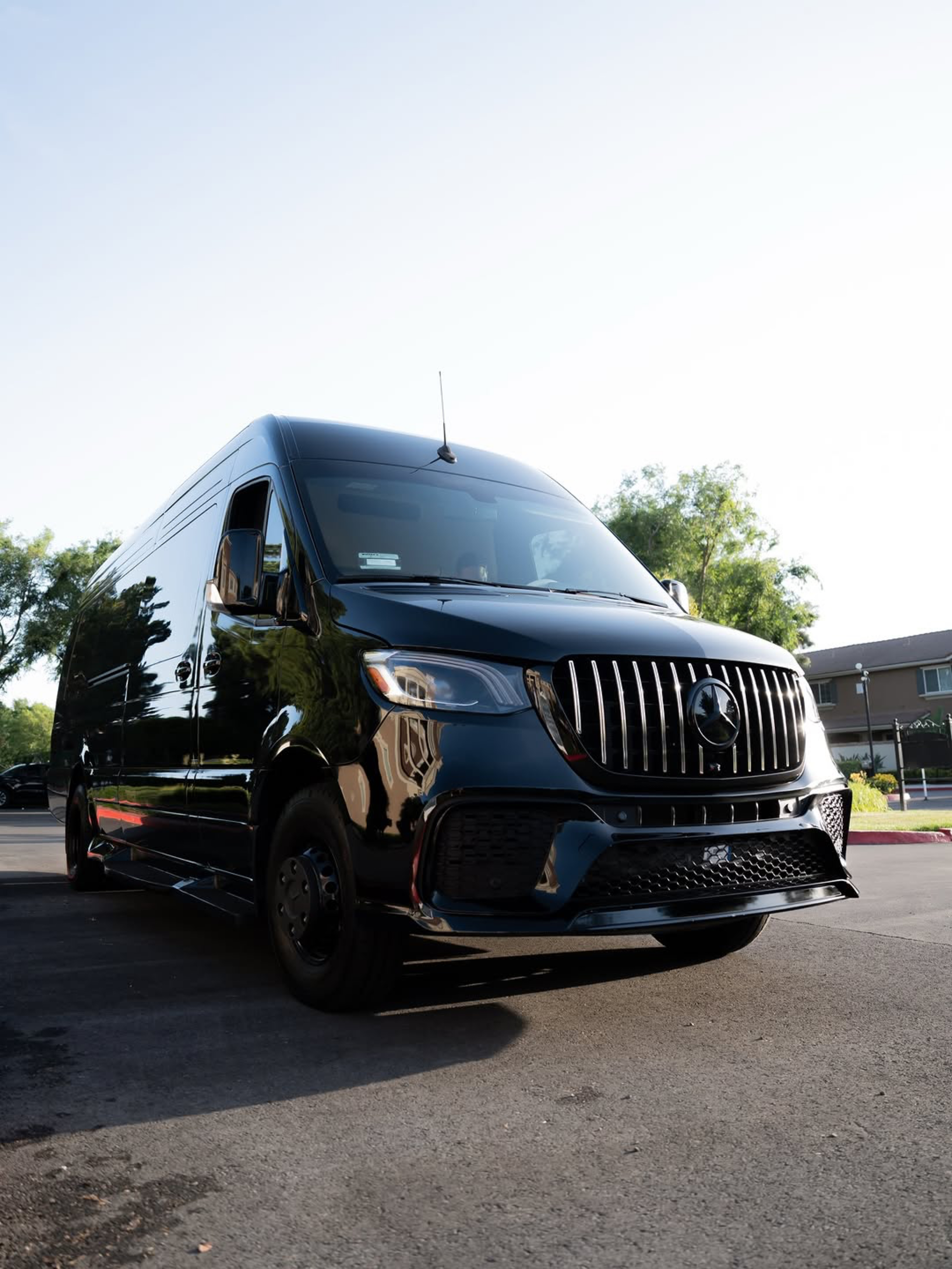 Black NU LUXE Transport van photographed outdoors from the front and side